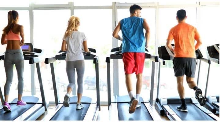 4 people running on a treadmill
